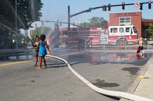 kids playing in fire hose water in Troy