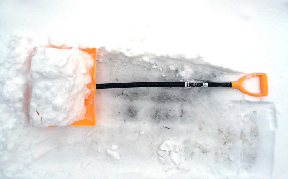 angled snow shovel in snow