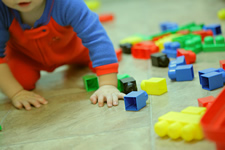 kid crawling with blocks