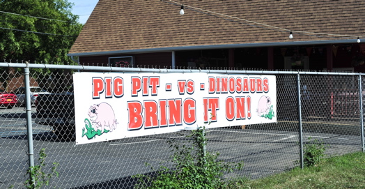 pig pit vs dino sign.jpg