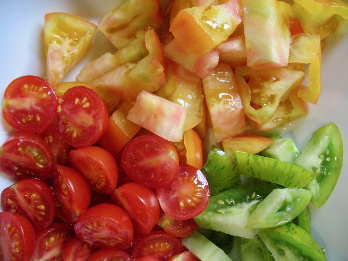 red and green and striped tomatoes cut up in bowl