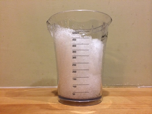 snow in a measuring cup