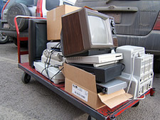 stack of old electronics on cart